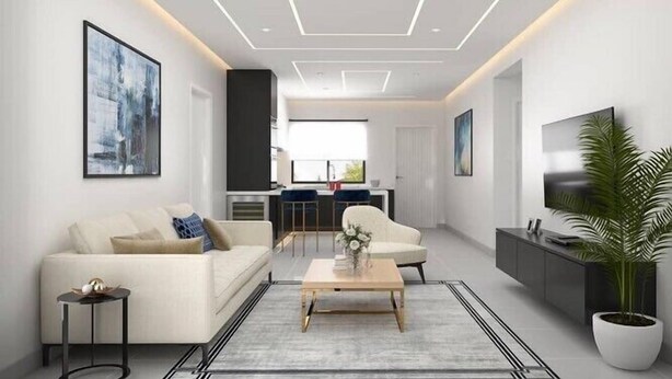 Ein modernes Wohnzimmer mit einer Couch, einem Couchtisch und einem Fernseher. Im Hintergrund befindet sich ein Küchenbereich mit einem Esstisch und Stühlen.