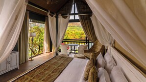 A bedroom with a large bed, a view of a balcony, and a table with chairs. - Canary Islands Resort & Spa (Paud)