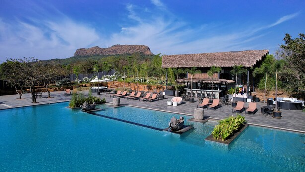 A pool area with lounge chairs, a bar, and a mountain view. - Canary Islands Resort & Spa (Paud)
