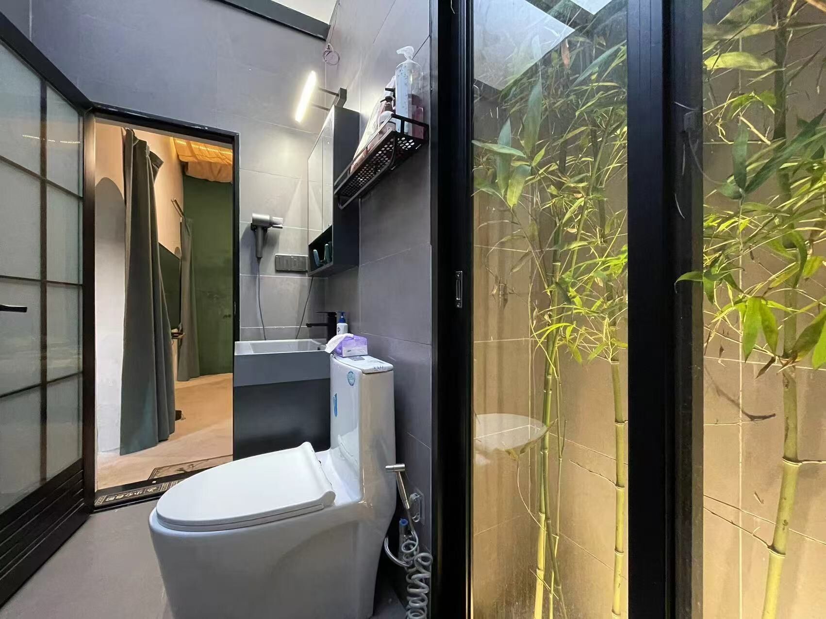 A modern bathroom with a toilet, shower, and sink.