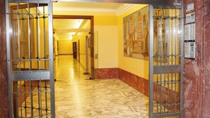 A hallway with marble flooring and metal security bars on the doors. - O Effe Games Vatican (Rome)