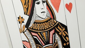 A playing card with a woman in a black and gold outfit, a red heart, and a black suit of spades. - O Effe Games Vatican (Rome)