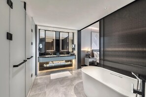A modern bathroom with a freestanding bathtub, a large mirror, and a vanity with a double sink. - Crowne Plaza Rugao (Nantong)