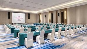 A conference room with rows of tables, white chairs, and a large screen displaying text. - Crowne Plaza Rugao (Nantong)