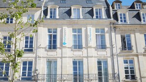 A historic building with multiple windows and balconies, featuring 'martapart' signage. - SmartAppart Caen République (Caen)