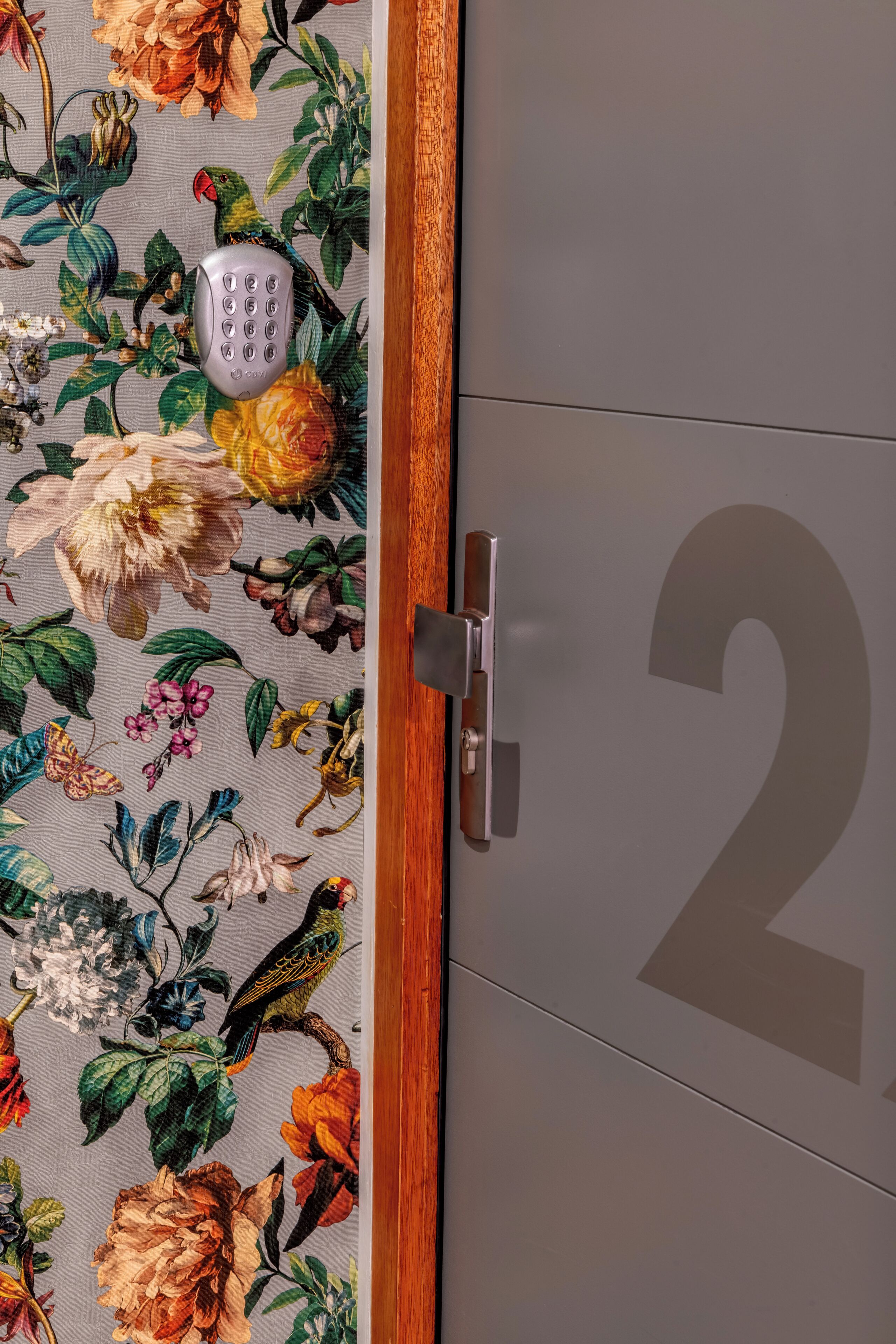 Una porta con carta da parati floreale e una serratura a codice.