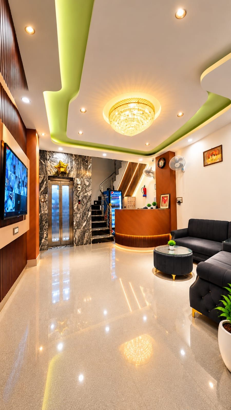 A hotel lobby with a reception desk, seating area, and a staircase leading to the upper floors.