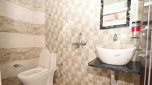 A bathroom with a toilet, sink, and shower. - Namah Inn (Varanasi)