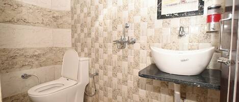 Une salle de bain avec des toilettes, un lavabo et une douche.