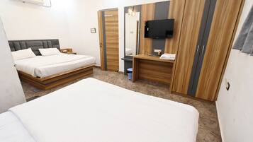 Ein Hotelzimmer mit einem großen Bett, einem Nachttisch, einem an der Wand befestigten Fernseher und einem Kleiderschrank.