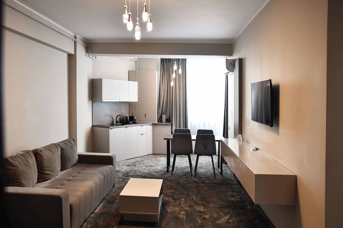 A modern living room with a sofa, coffee table, and a TV mounted on the wall.