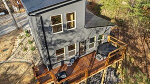 A two-story house with a deck and a covered outdoor seating area. - Black Bear by Beyond Expectations: 2BR Cabin w/ Hot Tub, Arcade, & Axe Throwing (Sevierville)