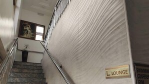A marble staircase with a metal handrail leading to a lounge area. - Apno Hotel and Suites  (Lekki)