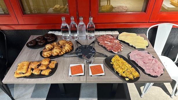 A table with various food items, including pastries, meats, and condiments, with a red background and a star-shaped centerpiece.
