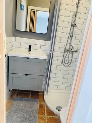 A bathroom with a white sink, mirror, and shower. - Apartment Tequila, City Center Studio Apartment (Almunecar)