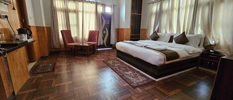 Un dormitorio con una cama grande, un escritorio y una silla.