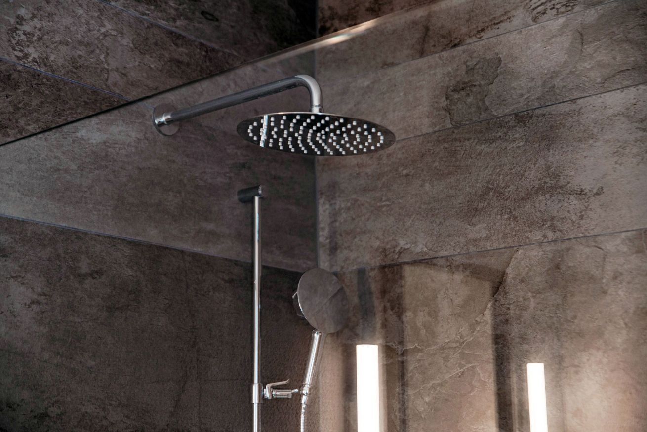 A modern shower with a rain shower head and a handheld shower attachment.