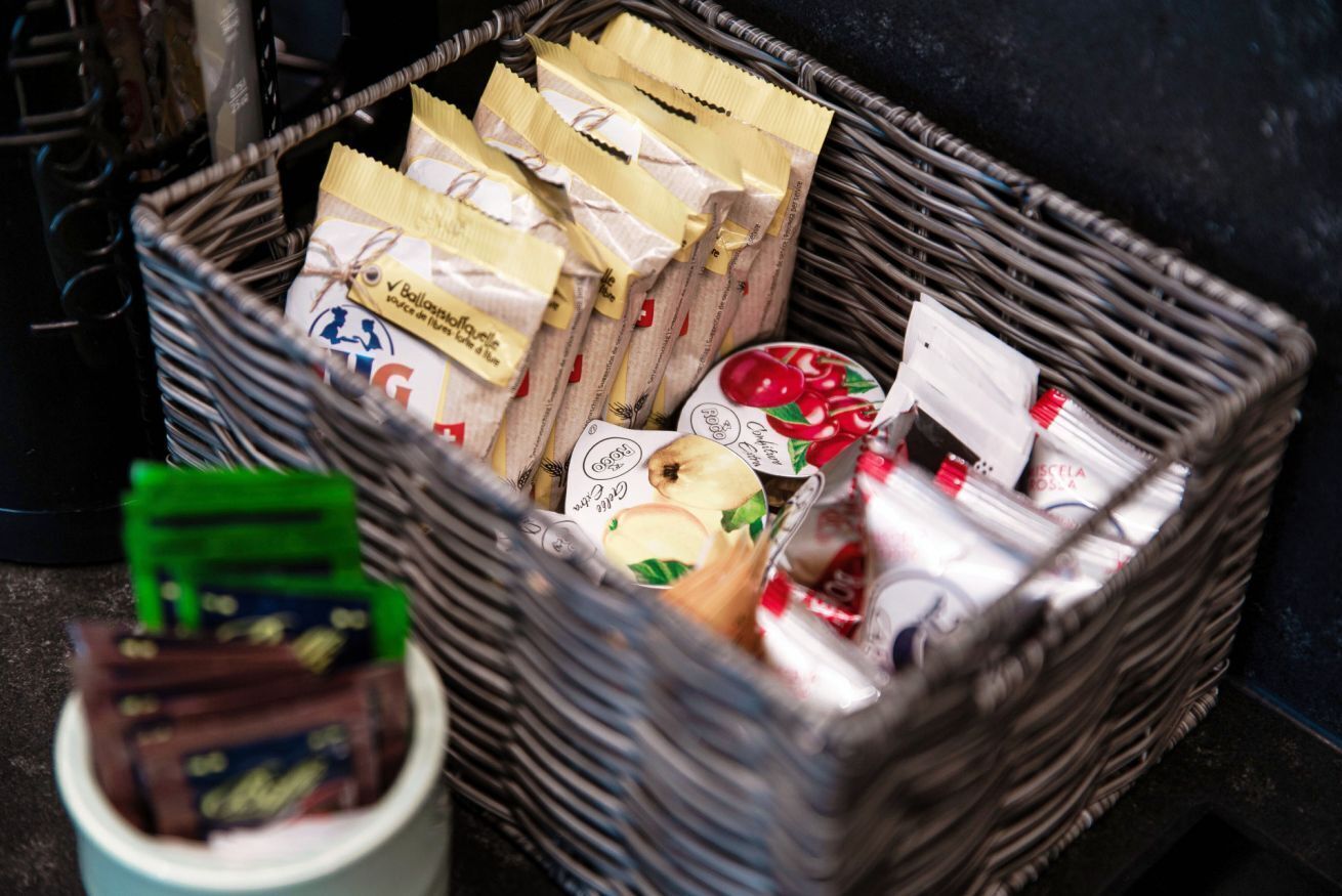 Ein Korbfesselkorb, gefüllt mit verschiedenen verpackten Lebensmitteln, darunter Snacks und Würzmitteln.