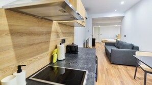 Una cocina moderna con estufa integrada, paneles de pared de madera y encimera gris.