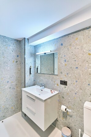 A bathroom with a white vanity, a mirror, and a toilet. - Apartamentos Beatriz by gaiarooms (Salamanca)