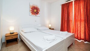 A double bed with white bedding, two bedside tables with lamps, a wall-mounted air conditioner, and a large floral painting. - Charming 2-bedroom apartment with AC, WiFi in enchanting Dubrovnik (Dubrovnik)