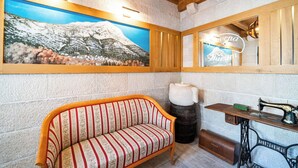 A cozy room with a wooden bench, a vintage Singer sewing machine, and a mountain painting on the wall. - Charming 2-bedroom apartment with AC, WiFi in enchanting Dubrovnik (Dubrovnik)