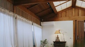 A spacious room with a long wooden table, a sofa, and a decorative lamp. - Hantang Inn Hostel Xi'an (Xi'an)