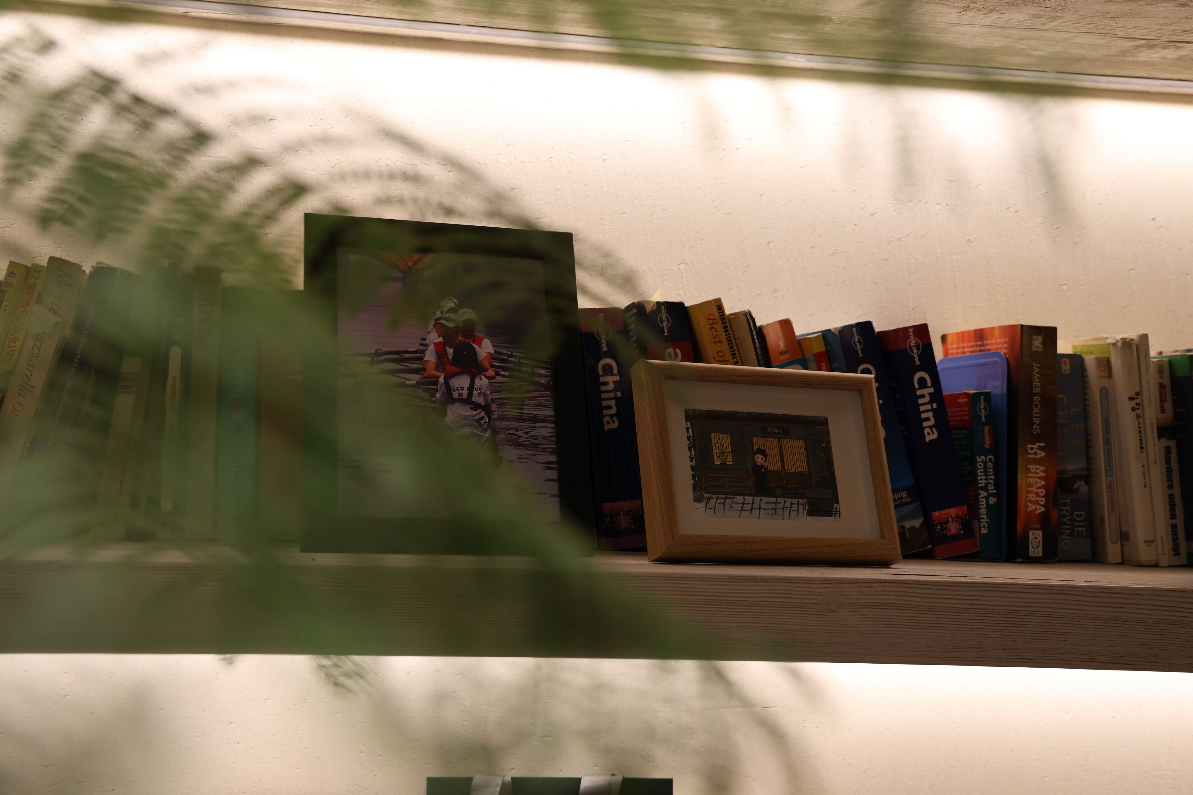 A bookshelf with books and a framed picture.