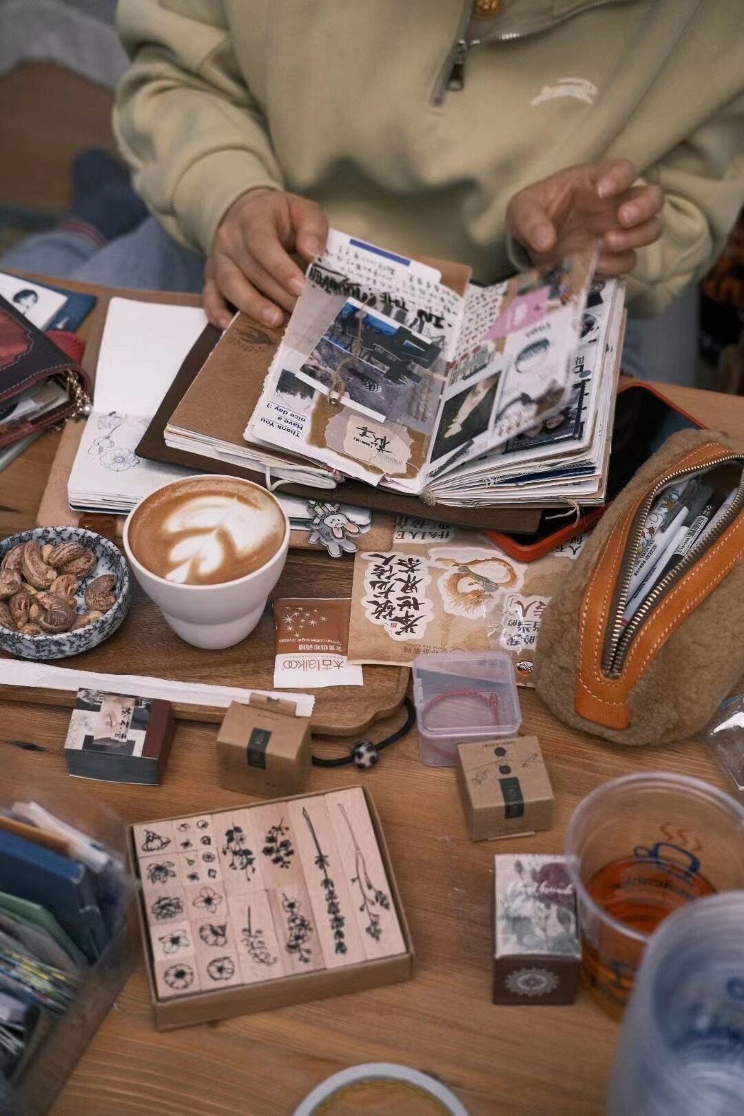 Un tavolo con un quaderno, una tazza di caffè e diversi articoli di cancelleria.