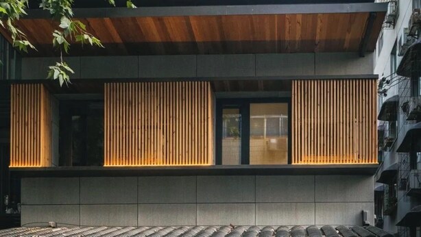 A multi-story building with a traditional tiled roof, wooden slatted balconies, and a sign indicating it is the Ban Tang Inn. - Hantang Inn Hostel Xi'an (Xi'an)