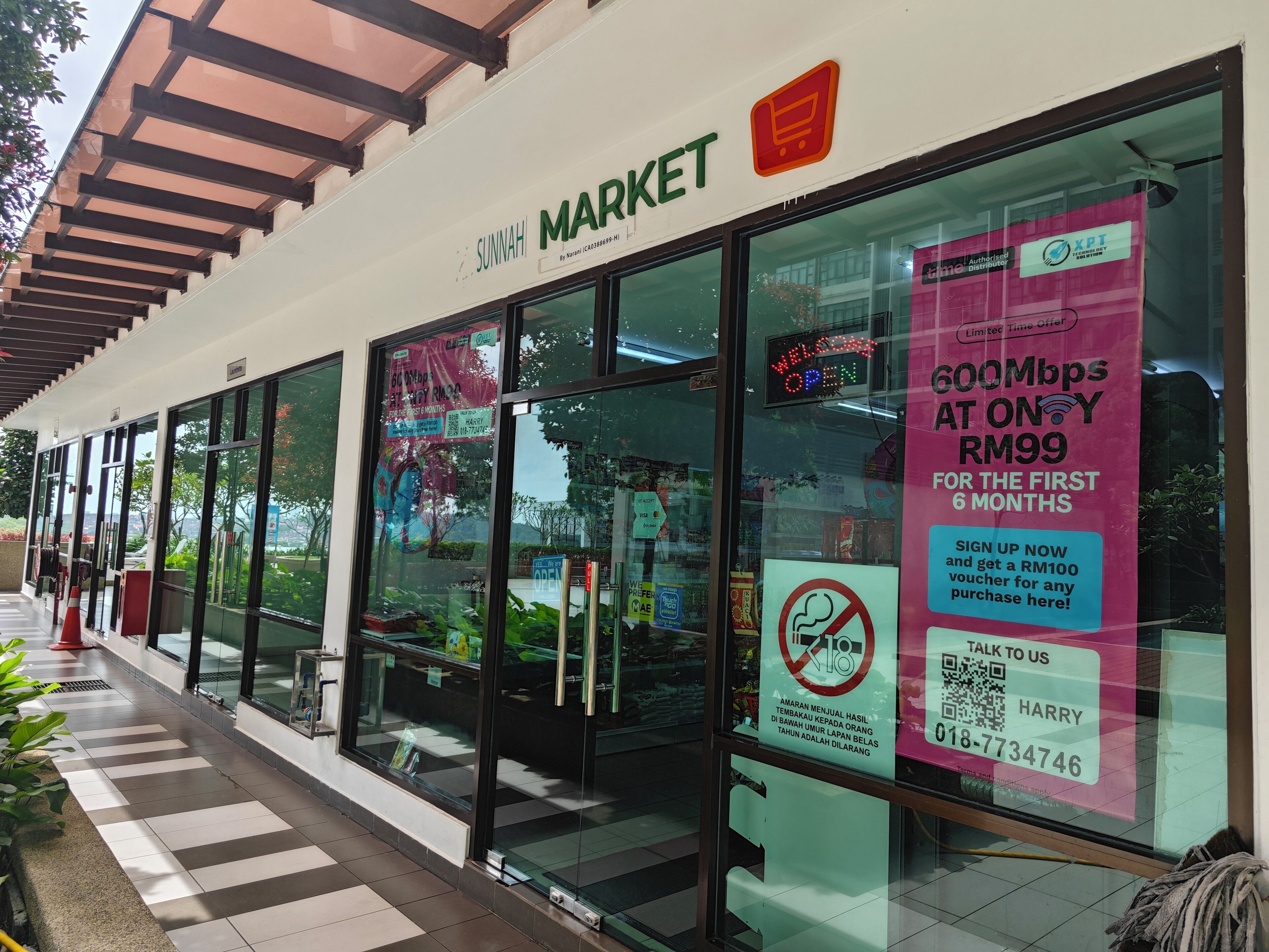 A storefront with a sign reading "SUNNAH MARKET" and a promotional sign offering 600Mbps internet for RM99.