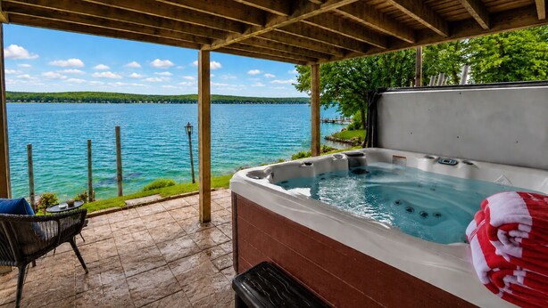 Un jacuzzi con vistas a un lago, una silla y una lámpara.