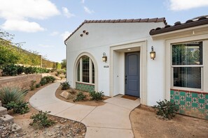 A house with a tiled exterior, a front door, and a mailbox.