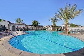 A swimming pool with clear blue water, surrounded by lounge chairs and palm trees. - Golfers' Retreat: Near PGA West & Luxury Pool (La Quinta)