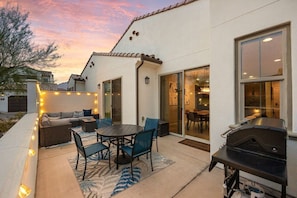 An outdoor patio with a dining table, chairs, a barbecue grill, and string lights. - Golfers' Retreat: Near PGA West & Luxury Pool (La Quinta)