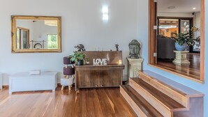 Un banco de madera con un letrero que dice 'LOVE', una estatua de Buda y un espejo en la pared.