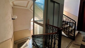 A staircase with ornate black railings, a glass door, and a tiled floor. - Green Heart House Napoli (Naples)