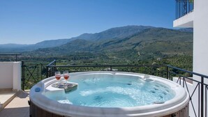 A hot tub on a balcony with a mountainous view.