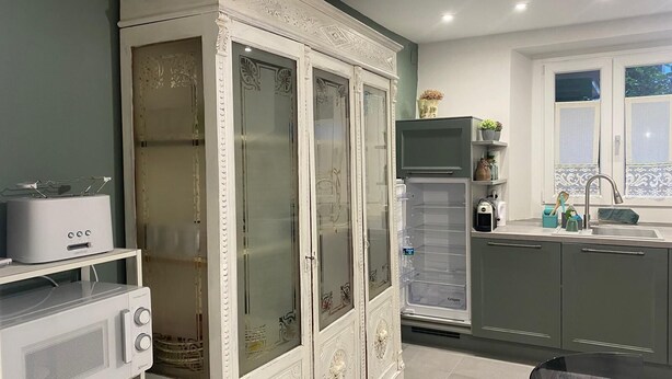 Eine moderne Küche mit einem weißen Schrank, einer Mikrowelle, einem Toaster und einem Kühlschrank.