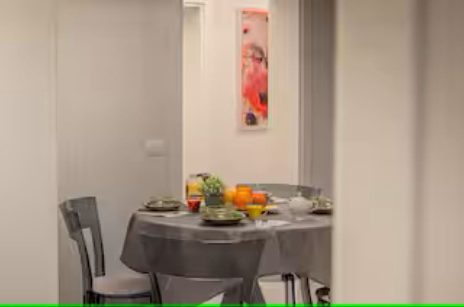 Ein Essbereich mit einem runden Tisch, gedeckt für vier Personen, umgeben von Stühlen.