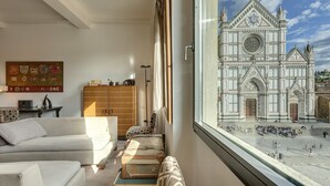 Un salon moderne doté d’une grande fenêtre donnant sur une cathédrale historique.