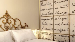 Un lit bien fait, avec des draps blancs et une tête de lit dorée. Des serviettes pliées sont posées sur le lit.