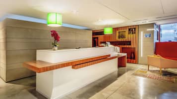 Welcome to our reception area, featuring a sleek reception desk, comfortable seating, and a beautiful vase with fresh flowers.