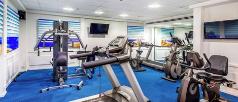 A gym with treadmills, elliptical machines, and weight equipment.