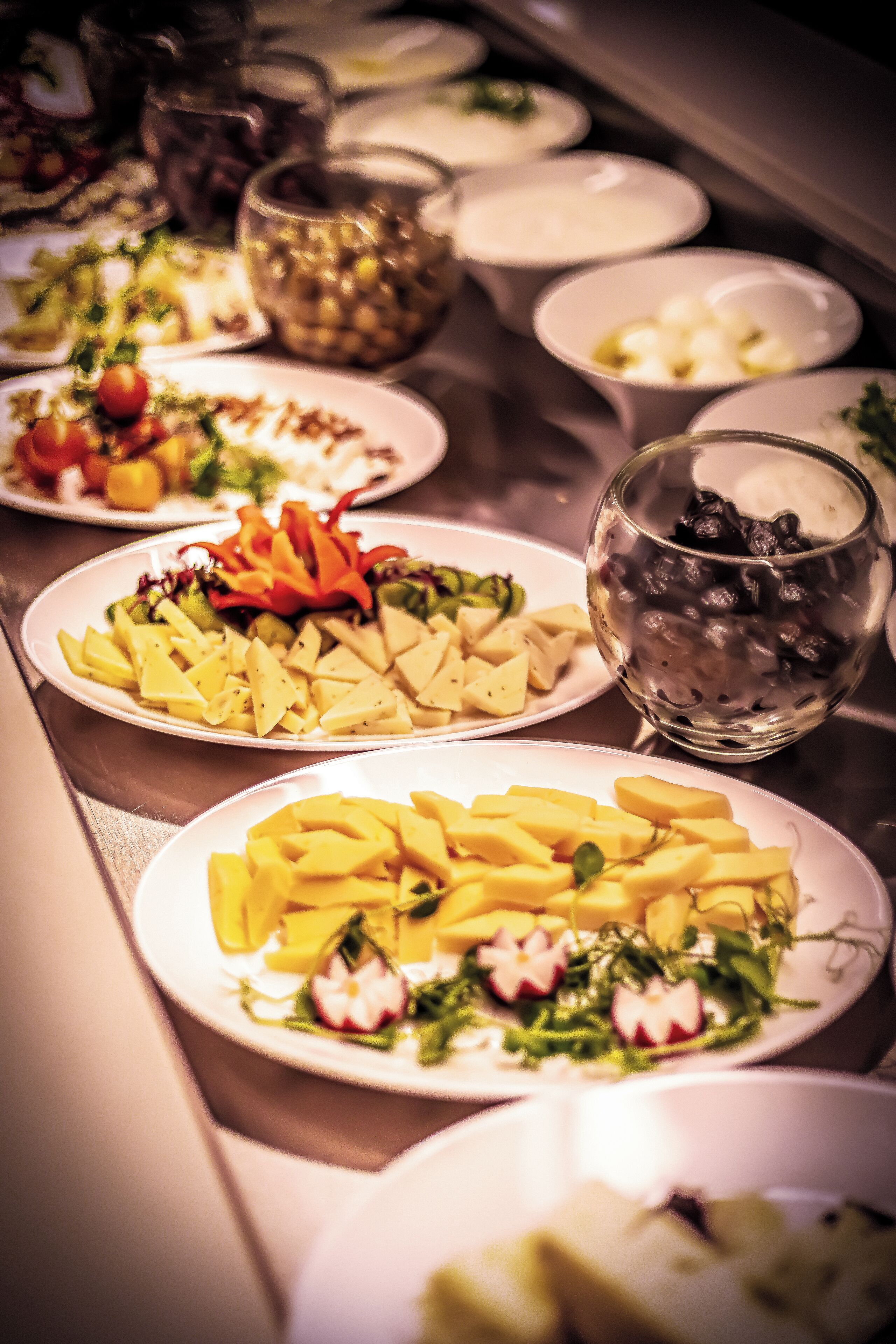 Un tavolo da buffet con diversi piatti, tra cui insalate, frutta e un bicchiere di bevanda fredda.