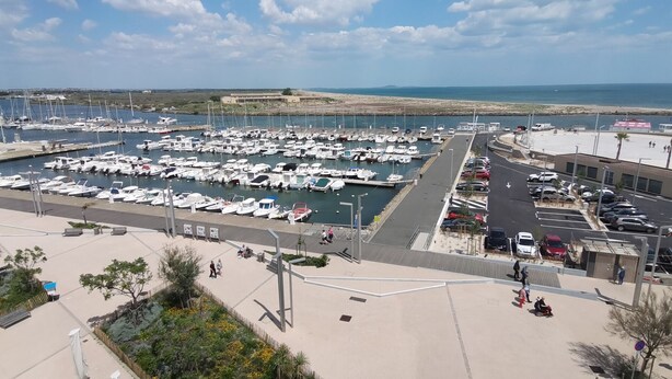 A marina with numerous boats docked, a parking area, and a promenade with benches and greenery. - Spacious apartment for 6, Valras-Plage center, 10m from the beach (Valras-Plage)