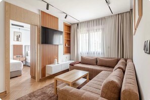 A modern living room with a sofa, a coffee table, and a TV mounted on the wall. - Centrico 2 Hospitality - Luxury & Comfort in the Center (Tangier)