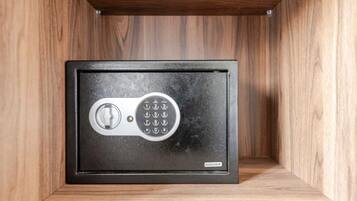 A safe deposit box with a combination lock, housed in a wooden cabinet.