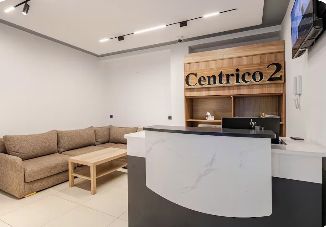 A reception area with a wooden desk, a sofa, and a coffee table.