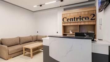 A reception area with a wooden desk, a sofa, and a coffee table.